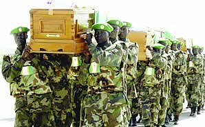 Ugandan troops serving under the AU mission in Somalia carry the coffins of the their colleagues at Mogadishu airport