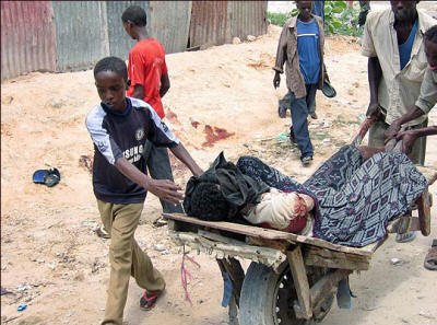 A Somali boy wheels his older brother's body